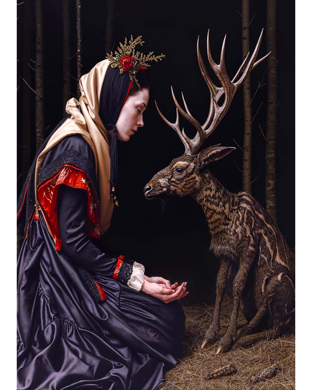 Woman feeding a deer in the dark forest
